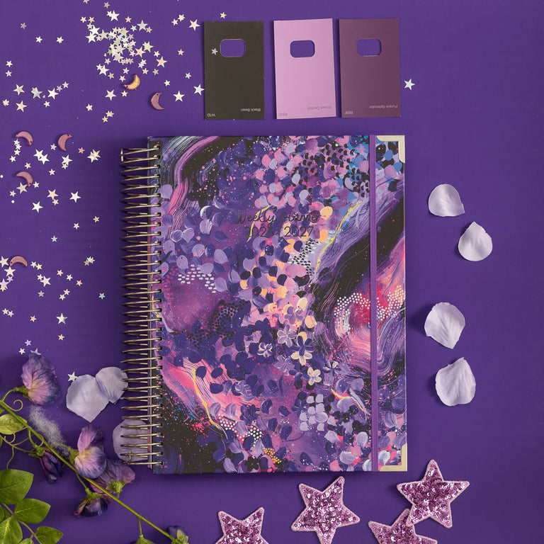 Decorative notebook with floral design on a purple background with decorative elements.