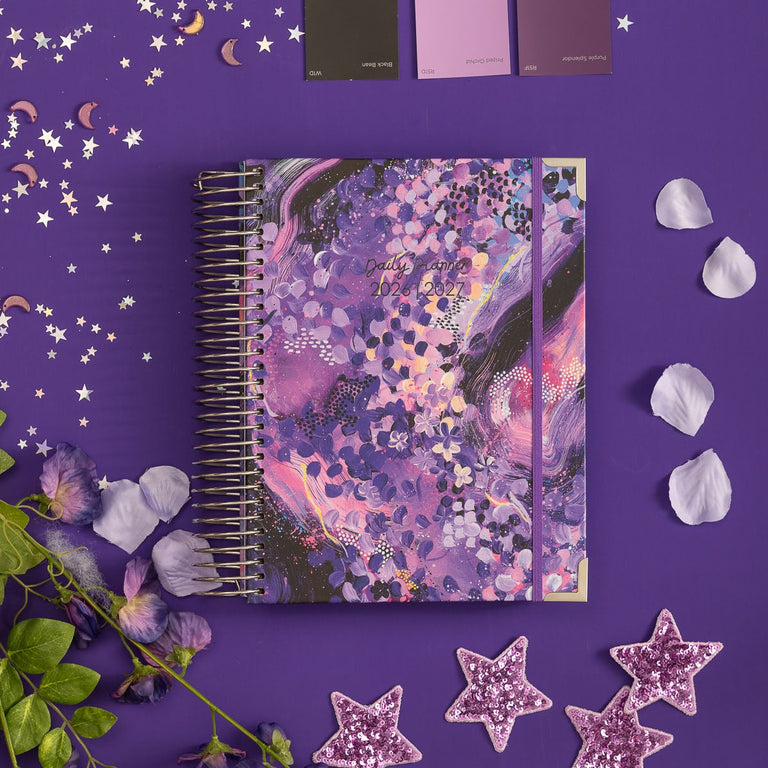 Purple notebook with floral design on a purple background with decorative elements