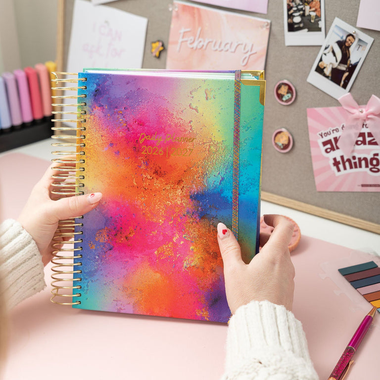 Colorful planner held by hands with a decorative background