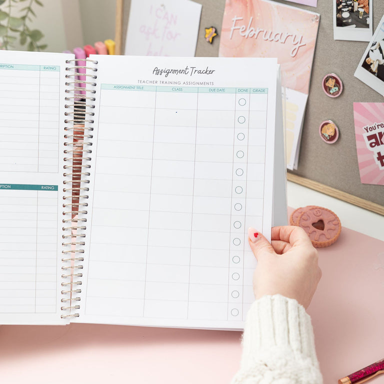 Person holding a spiral-bound planner with a checklist on a desk with decorative items.