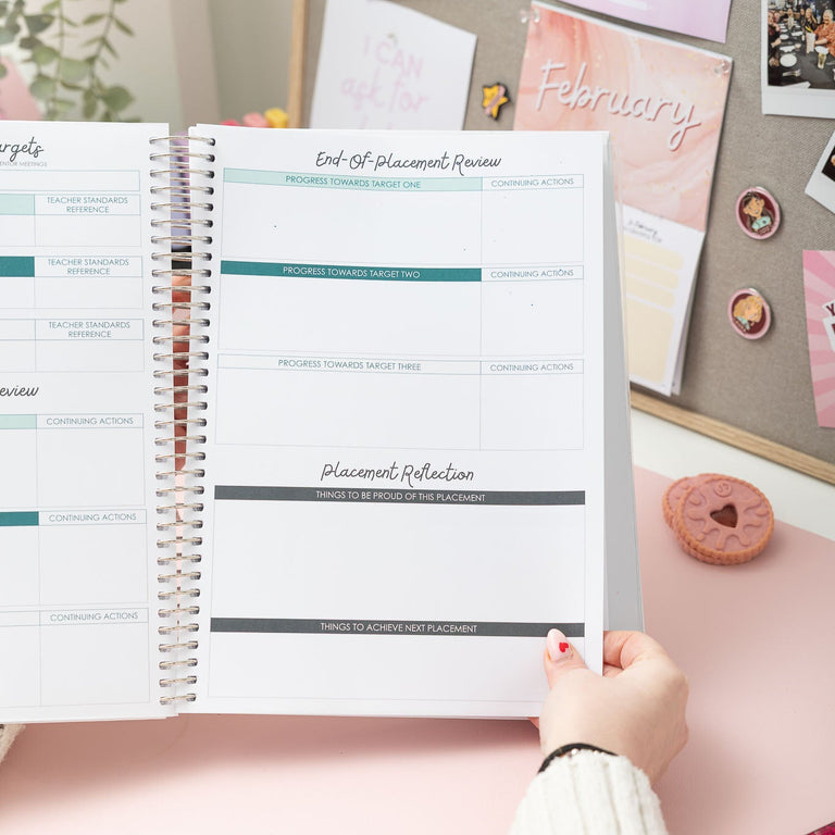 Person using a planner with decorative items on a desk