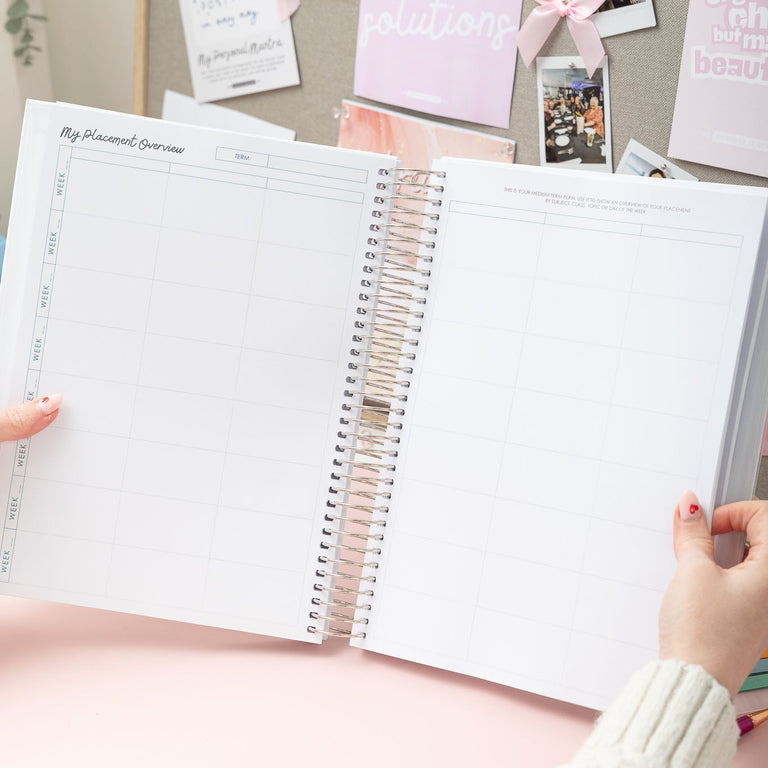 Person holding a spiral-bound notebook with a pink and white decorative background