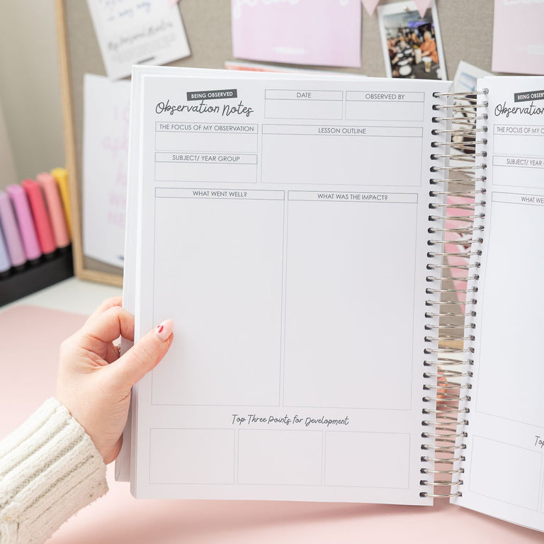 Person holding a spiral-bound notebook with pregnancy observation pages against a neutral background.