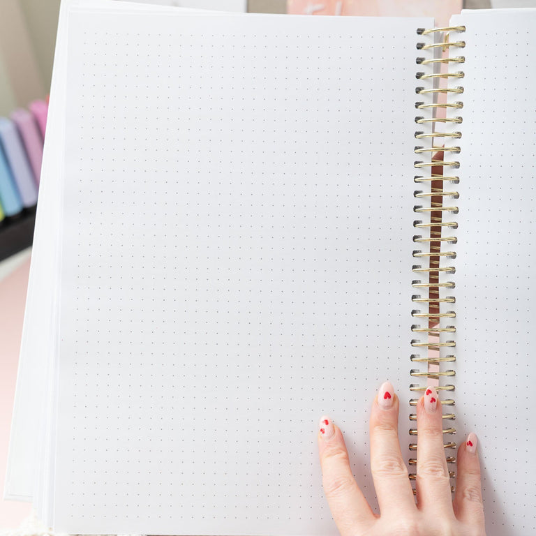 Open notebook with a hand on a light background
