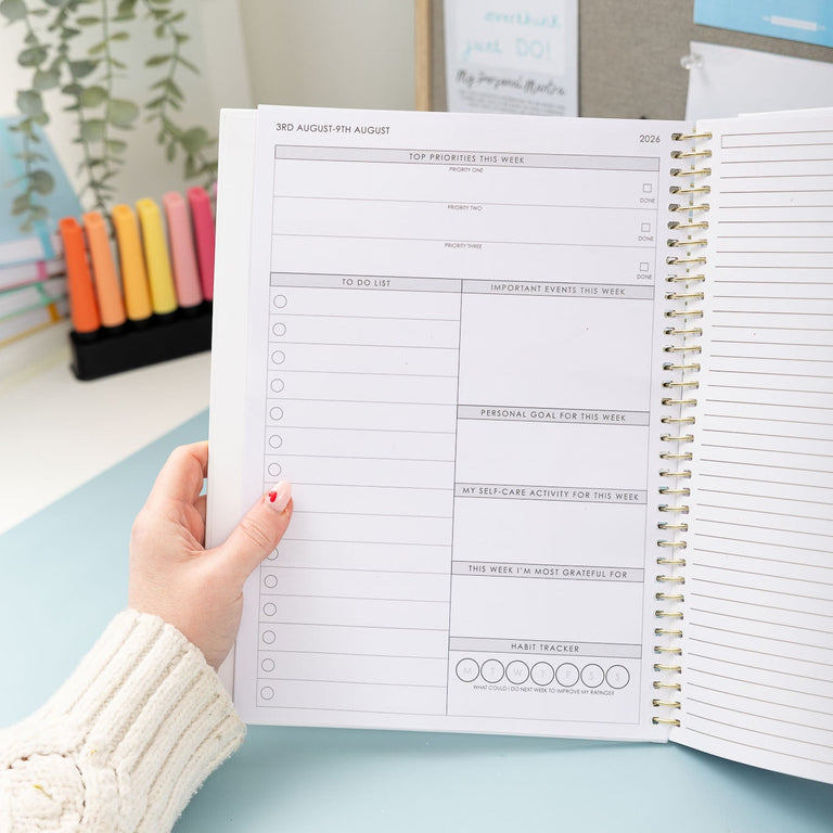 Person holding an open planner with a decorative background
