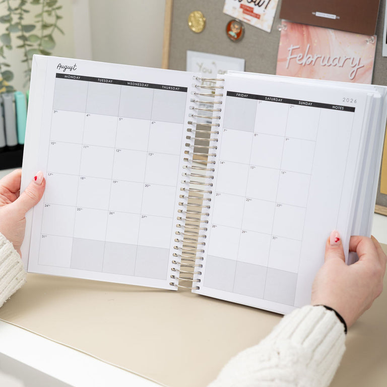 Person holding an open planner with a decorative background