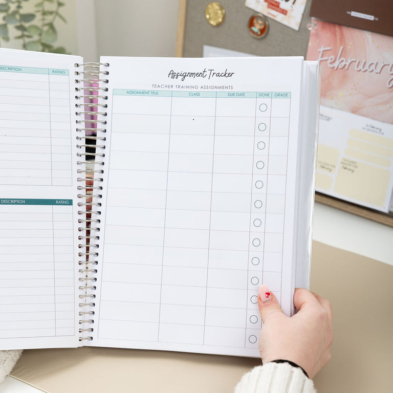 Person holding a planner with an assignment tracker page, surrounded by office decor.