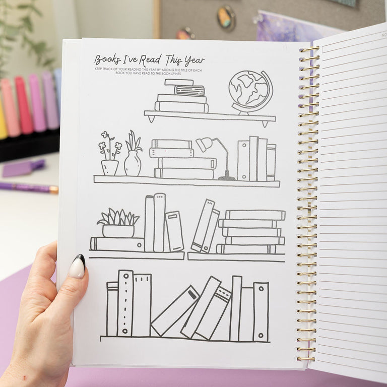 Person holding a book with line art of books on shelves against an open notebook.