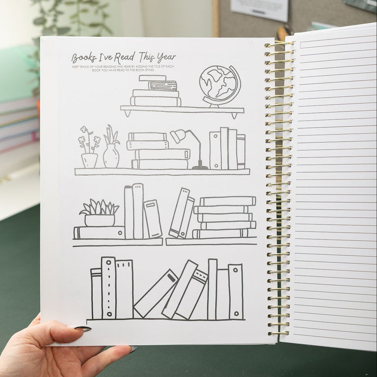 Person holding a notebook with line drawings of bookshelves.