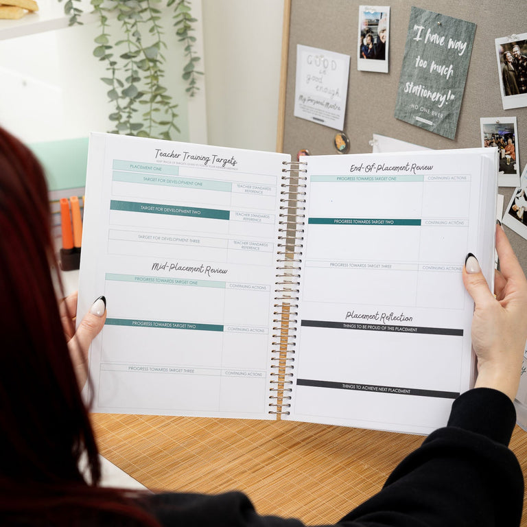 Person holding a spiral-bound planner with a home office background