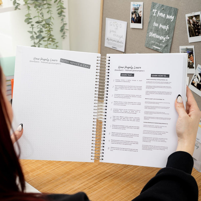 Person holding an open planner with a home office background