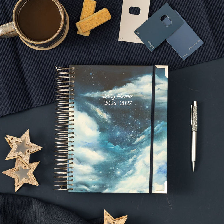 Calendar, pen, mug, and decorative items on a dark surface