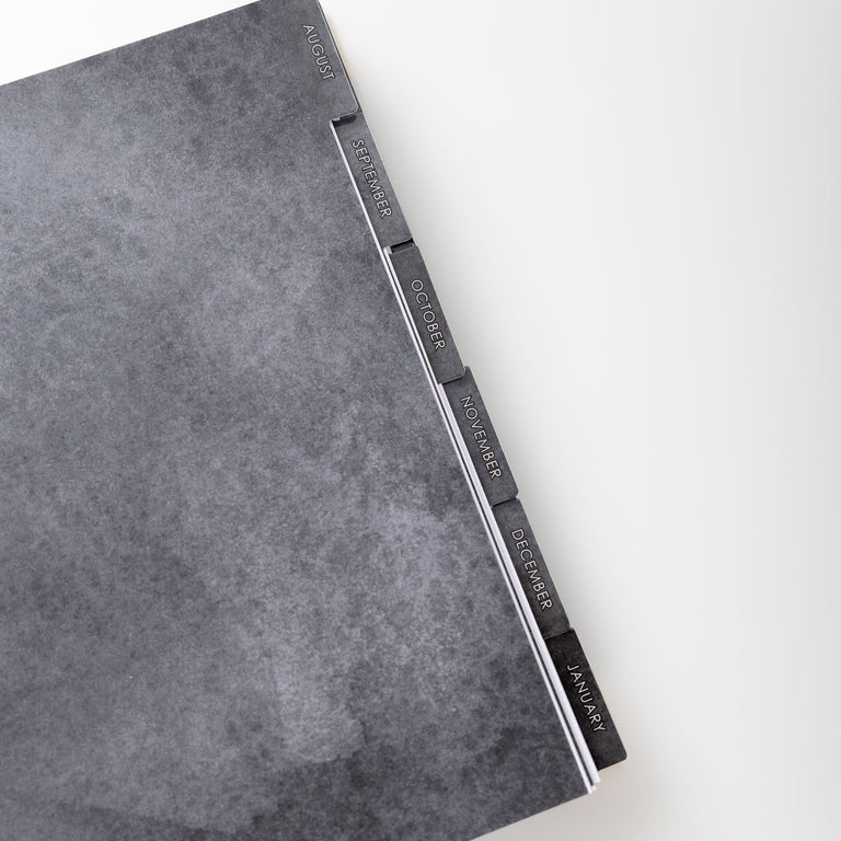 Gray textured notebook with a metal clip on a white background