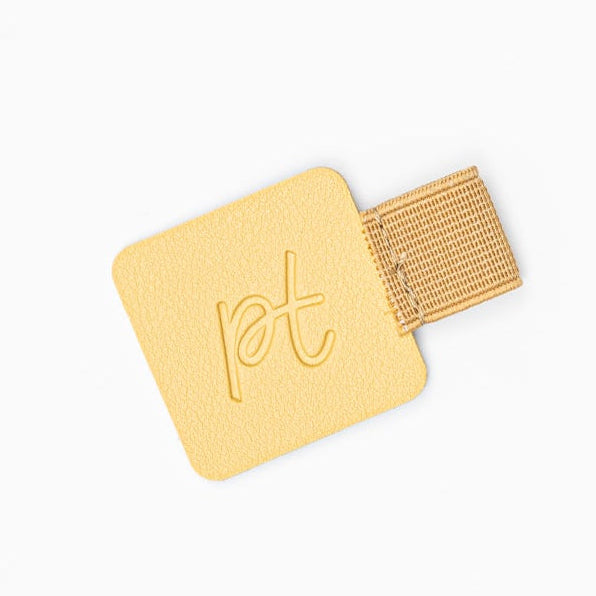 Yellow pet tag with a gold band on a white background