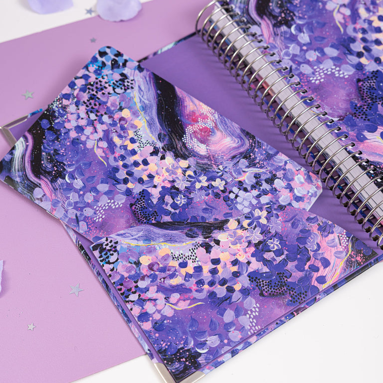 Purple notebook with floral design on a white background