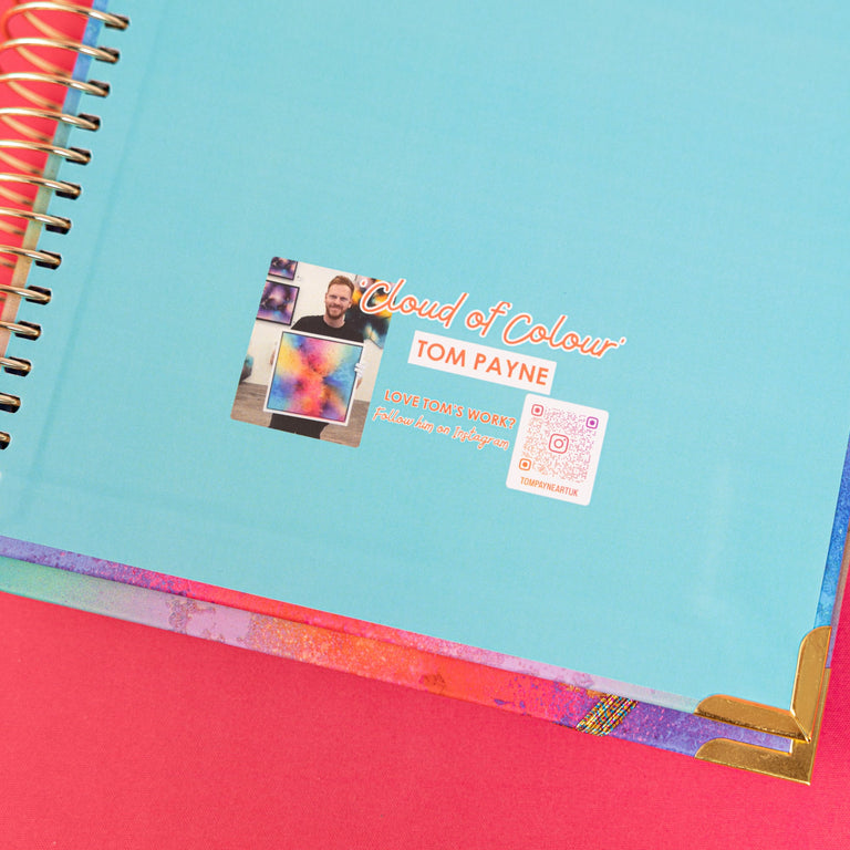 Notebook with a colorful cover and visible branding on a red surface